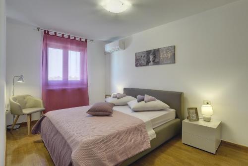 ein Schlafzimmer mit einem Bett, einem Stuhl und einem Fenster in der Unterkunft Villa Erica in Pula