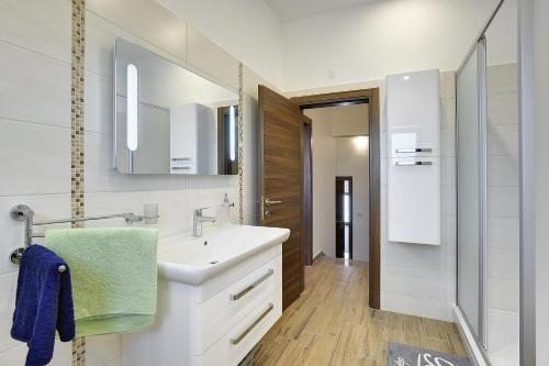 ein weißes Badezimmer mit einem Waschbecken und einem Spiegel in der Unterkunft Villa Erica in Pula