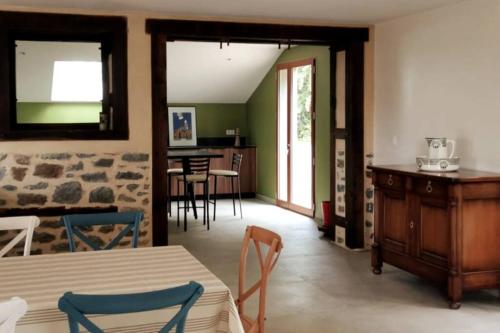 ein Wohnzimmer mit einem Tisch und Stühlen sowie eine Küche in der Unterkunft Grange moderne près de Rennes avec jolie vue ! in Gévezé