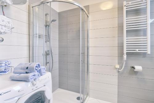 a bathroom with a shower and a washing machine at Appartement Tiffany in Ližnjan