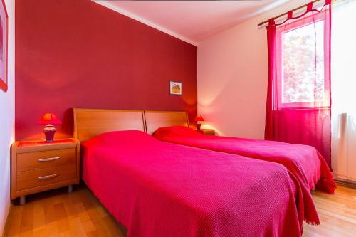 2 camas en un dormitorio con paredes rojas en Tolle Ferienwohnung mit großem Pool, 2 Schlafzimmer, Klima, WLAN, Observatorium, Volleyballfeld, Tischtennis und Kicker, en Valtura
