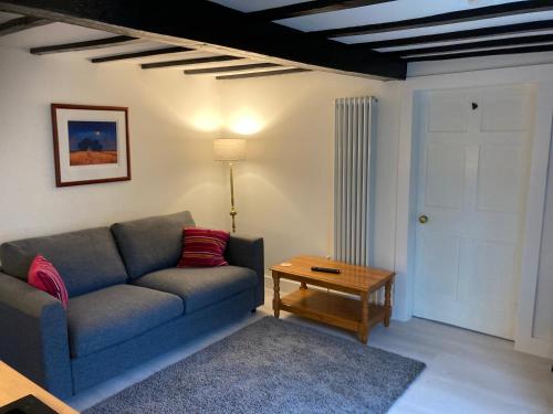 uma sala de estar com um sofá e uma mesa em Bryntirion Farmhouse Apartment with Hot Tub em Llanfair Caereinion