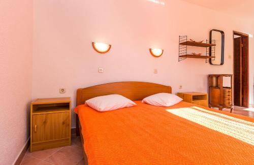 a bedroom with an orange bed with two pillows at Ferienwohnung nur 700 Meter bis zum Sandstrand mit Pool, Küche, Bad, Balkon, BBQ in Medulin