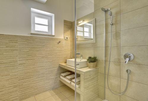 een badkamer met een douche, een wastafel en een spiegel bij Schöne Finca mit privatem Pool, Klima, WLAN, Terrasse, Grill in Kavran