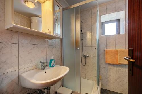 a bathroom with a sink and a shower at Istrisches Ferienhaus mit Klima, WLAN, Terrasse, Parkplatz und Grillbereich in Rakalj