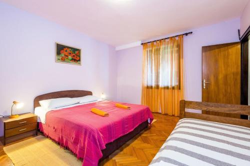 a bedroom with a bed with a red bedspread at Traumhaft nur 400 Meter zum Strand in Banjole