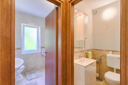 a bathroom with a toilet and a sink at Im Jahr 2014 renoviertes Ferienhaus 400 Meter zum Strand in Premantura