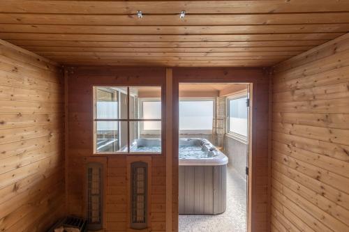 Villa für große Ansprüche mit großem Pool, Sauna, Whirlpool, Billard في ليجيان: غرفة خشبية مع حوض في الوسط