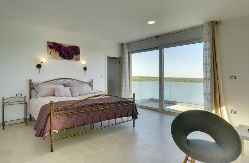 a bedroom with a bed and a large window at Traumhafte Villa mit privatem Pool, Sauna, Meerblick in Peroj
