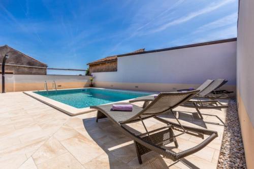 a patio with two chairs and a swimming pool at Wunderschöne Villa mit privatem Pool, Klima, WLAN in Valtura