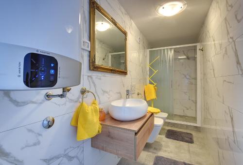een badkamer met een wastafel, een toilet en een spiegel bij Typisch istrisches Ferienhaus mit privatem Pool, Tischfußball, Darts, Gym in Mednjan
