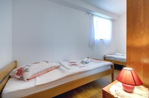 a bedroom with a bed and a lamp on a table at Oberhalb des Limfjords liegt diese Ferienwohnung mit Pool, Terrrasse und Grillplatz in Barat