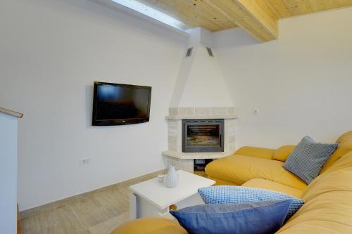 a living room with a yellow couch and a fireplace at Villa Paola in Divšići
