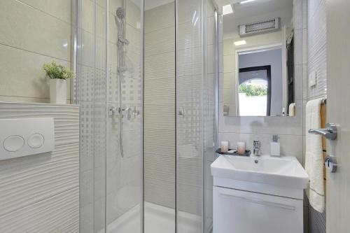 a white bathroom with a sink and a shower at Villa Paola in Divšići