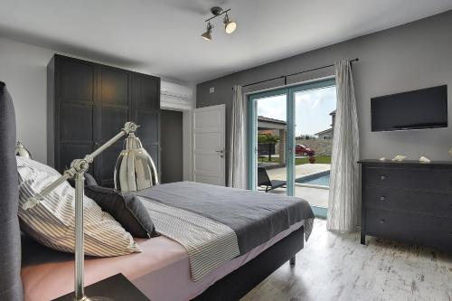 Schlafzimmer mit einem Bett und einer Glasschiebetür in der Unterkunft Villa Desire in Juršići