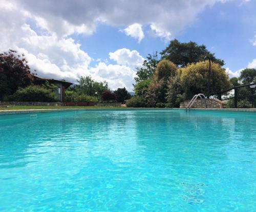 una grande piscina con acqua blu di Ferienhäuschen CLAUDIO mit Pool in Tignale a Olzano