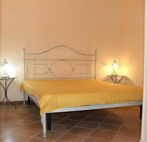un letto in una stanza con due lampade su due tavoli di Ferienhäuschen CLAUDIO mit Pool in Tignale a Olzano