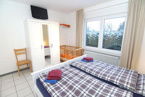 - une chambre avec 2 lits et une fenêtre dans l'établissement Bungalow Windstille, à Norddeich