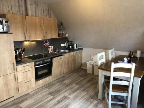 諾登的住宿－Fewo Imke，厨房配有木制橱柜、桌子和水槽。