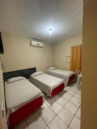 a hotel room with two beds and a window at Hotel Horizonte in Teresina