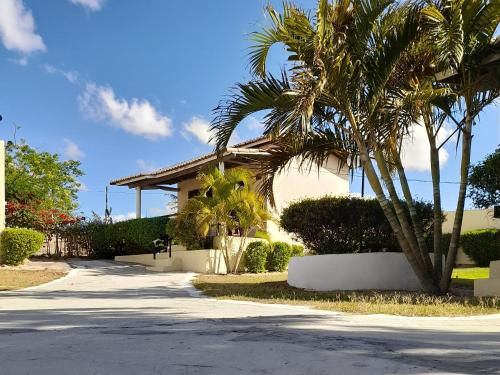 a house with palm trees in front of a street at Pousada Vale Encantado in Serra de São Bento