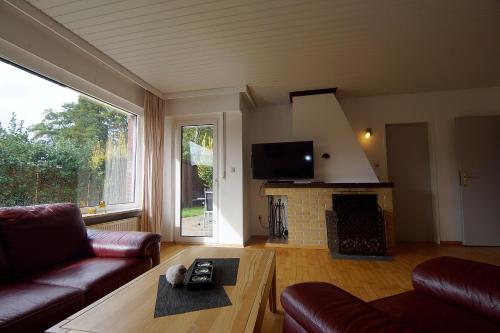 Una sala de estar con un sofá y una chimenea. en Bungalow Hohes Riff, en Norddeich