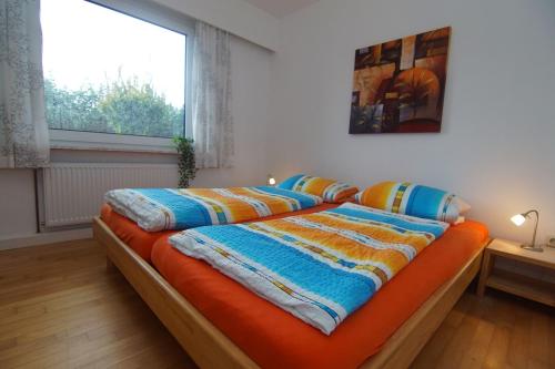 a bed with two pillows on it in a room at Bungalow Hohes Riff in Norddeich