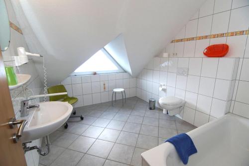 biała łazienka z umywalką i toaletą w obiekcie Haus Anne w mieście Norddeich