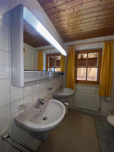 a bathroom with two sinks and a mirror at Haus Gneuss in Reit im Winkl