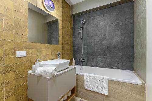 a bathroom with a tub and a sink and a shower at Grandis Residence Apartment in Braşov