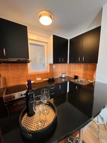 una cocina con una mesa con copas de vino. en Miss apartman, en Jagodina