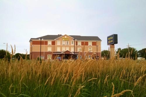a building in the middle of a field of tall grass at MainStay Suites Grand Island in Grand Island