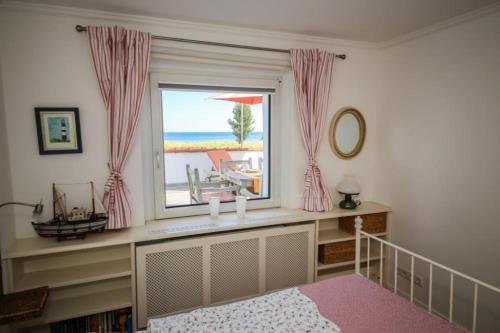シャルボイツにあるFerienwohnung Barebicaのビーチの景色を望む窓付きのベッドルーム1室