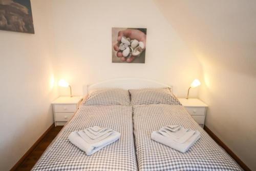 ハーフクルークにあるFerienwohnung Kutter Haus Duckdalbenのベッドルーム1室(ベッド1台、タオル2枚付)
