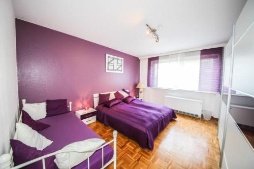 ティメンドルファー・シュトラントにあるFerienwohnung Sandburgの紫色のベッドルーム(ベッド2台、窓付)