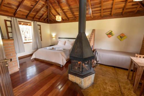 a bedroom with a wood stove in a room at Pousada Serra Vista in Gonçalves