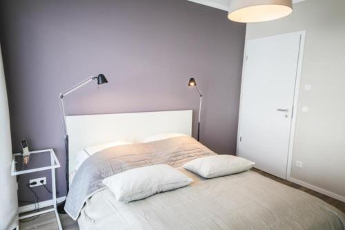 ハーフクルークにあるFerienwohnung Stranderlebnisの白いベッドルーム(枕2つ付きのベッド1台付)