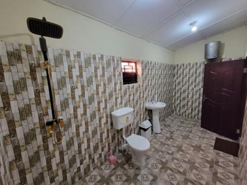 een badkamer met een toilet en een wastafel bij Nicely Furnished Comfortable Holiday Apartment Home at Yarambamba Estate in Yundum