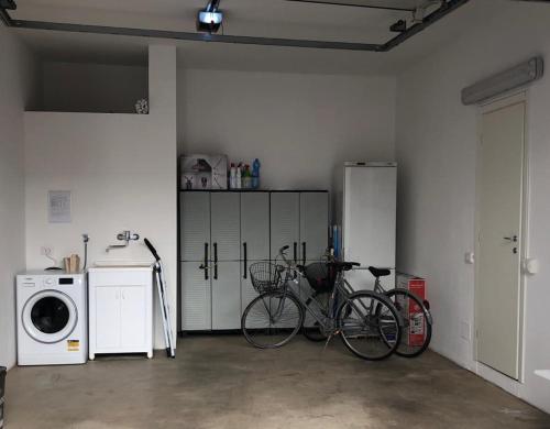 a room with two bikes and a washing machine at Greta's house in Forlì