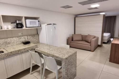 a kitchen with a table and chairs and a couch at Imperial Flat Tambaú in João Pessoa