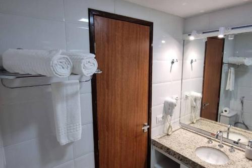 uma casa de banho com um lavatório e uma porta de madeira em Imperial Flat Tambaú em João Pessoa