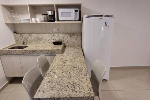 若昂佩索阿的住宿－Imperial Flat Tambaú，厨房配有柜台和白色冰箱。