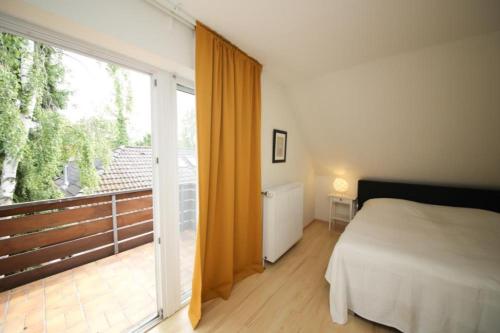 a bedroom with a bed and a large sliding glass door at Ferienhaus Strandräuber in Timmendorfer Strand