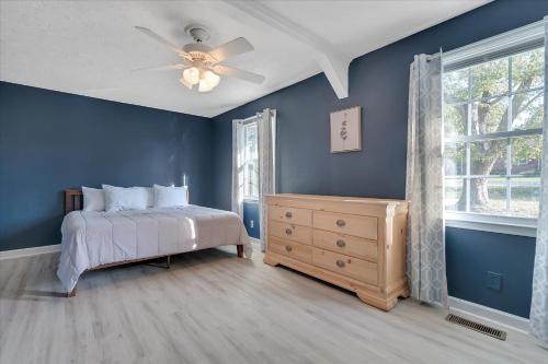 a bedroom with blue walls and a bed and a window at The Kentucky Bluegrass Retreat in Frankfort