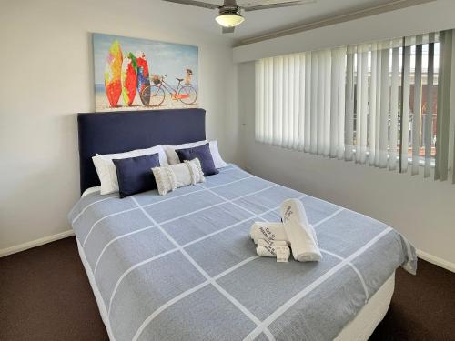 una camera da letto con un grande letto blu con scarpe sopra di H2O Holiday Apartments Unit 12 a North Haven