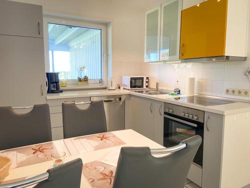 a kitchen with a table and some chairs and a table and a counter at Bootsmann Gollendorf – mit eingezäuntem Garten in Gollendorf