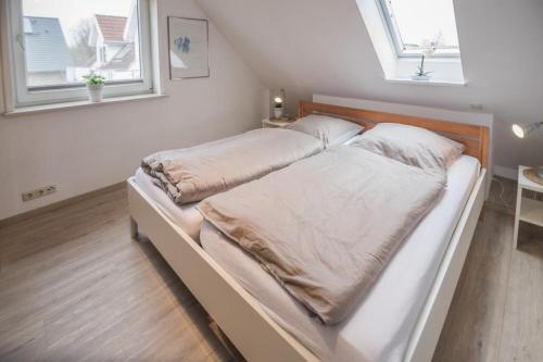 a large bed in a room with two windows at Captain´s Suite in Gollendorf – mit Kaminofen in Gollendorf