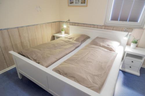 1 dormitorio con 2 camas y mesita de noche en Sonnenoase en Fehmarn