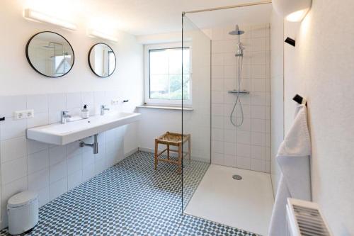 een witte badkamer met een wastafel en een douche bij Freistehendes Landhaus Paco mit 2100qm eingezäuntes Grundstück, Kamin, Sauna und besuchen Sie die Alpakazucht in der Nachbarschaft in Blaufelden