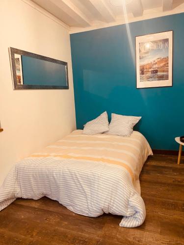 une chambre avec un lit avec un mur bleu dans l'établissement Au porte du château, à Chinon